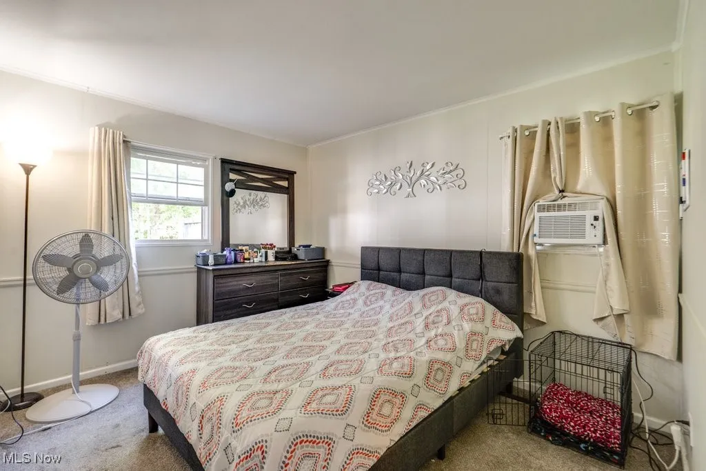 Carpeted bedroom with ornamental molding and baseboards