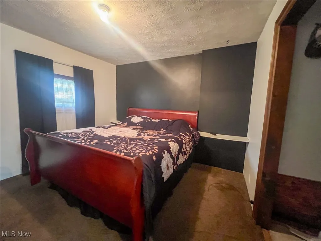 Carpeted bedroom with a textured ceiling