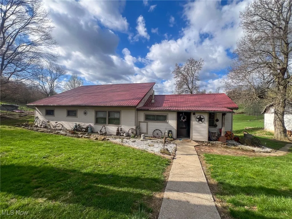View of front of house with a metal roof and a front lawn