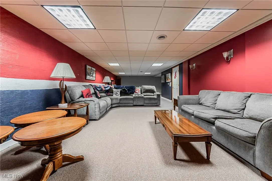 Living room with a paneled ceiling and carpet floors