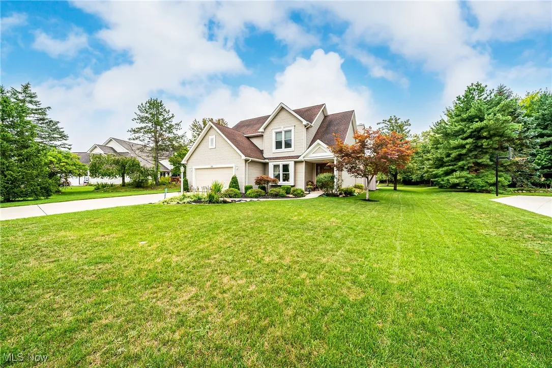 View of front facade featuring a front lawn, driveway, and an attached garage