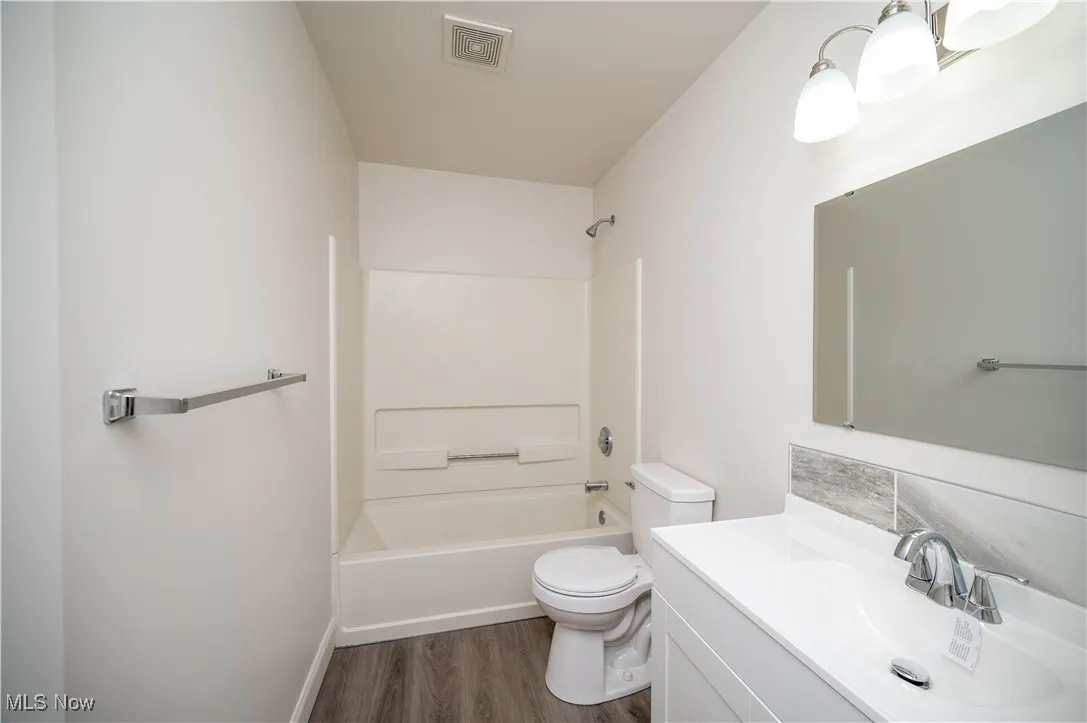 Bathroom with vanity, shower / washtub combination, and dark wood-type​​‌​​​​‌​​‌‌​‌‌​​​‌‌​‌​‌​‌​​​‌​​ flooring
