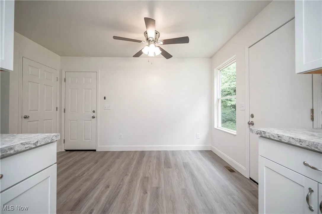 Unfurnished dining area featuring light wood-style flooring and a ceiling fan