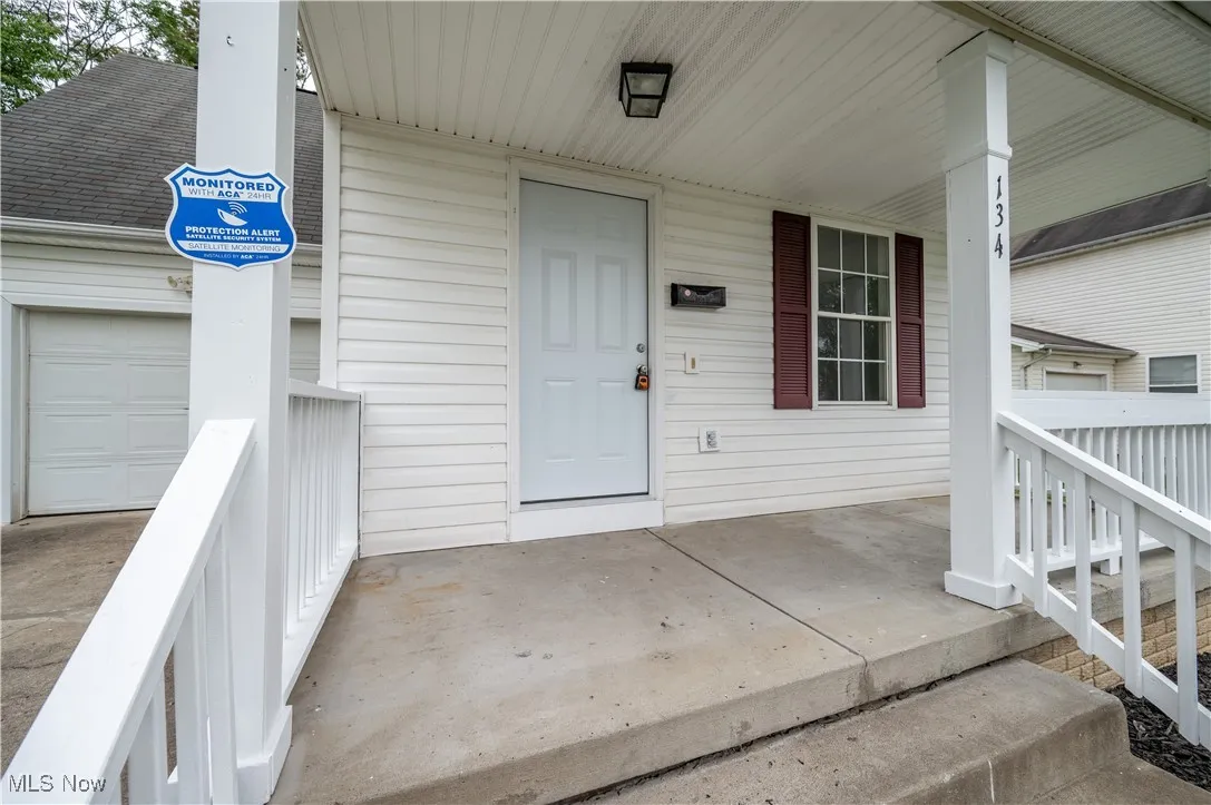 Doorway to property featuring a porch and an attached garage