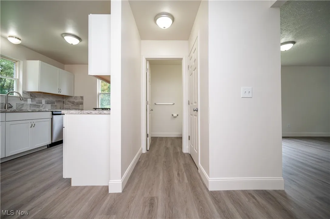 Hallway featuring light wood-style floors and a textured ceiling