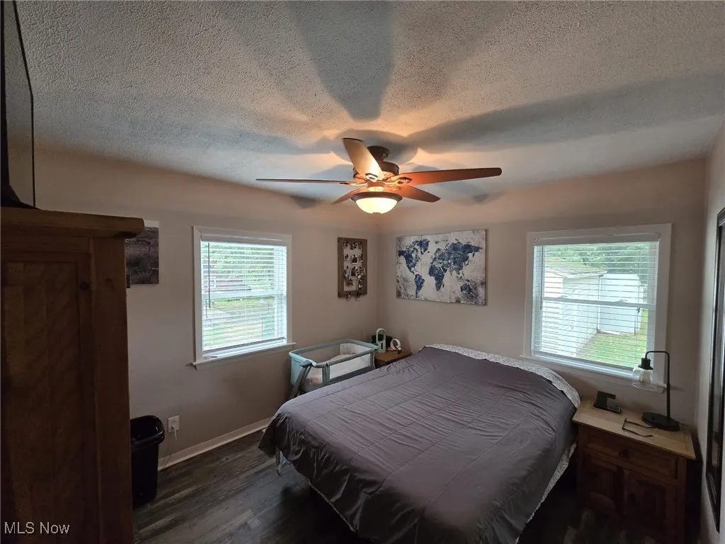 Large Bedroom with dark wood-style floors, a textured ceiling, and a ceiling fan