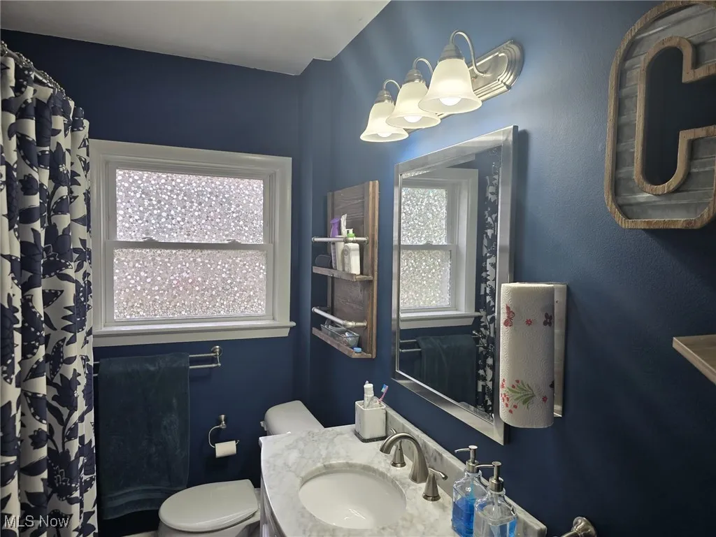 Bathroom featuring a shower with curtain, marble vanity, new tub, and privacy window