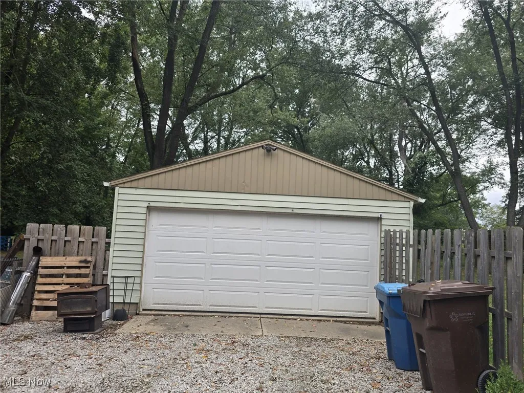 Detached 2 car garage with view of scattered trees