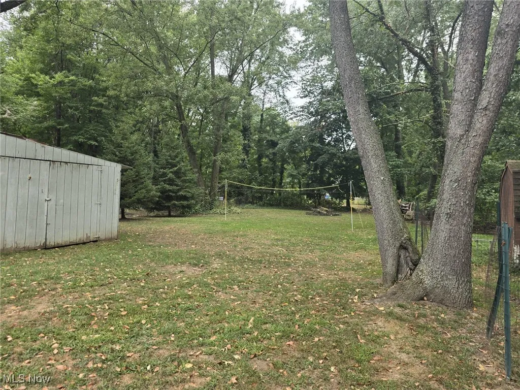 View of grassy yard featuring an outbuilding