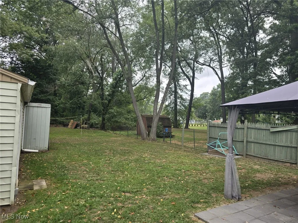 View of yard with a shed and view of scattered trees