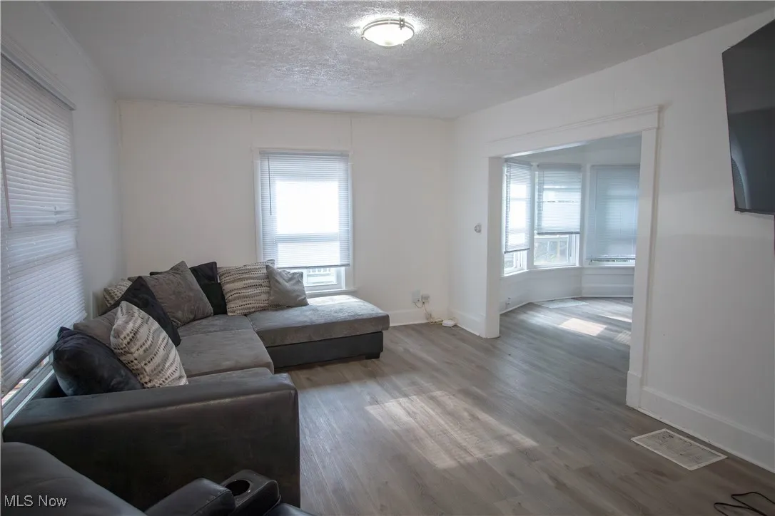 Living area featuring wood finished floors and a textured ceiling