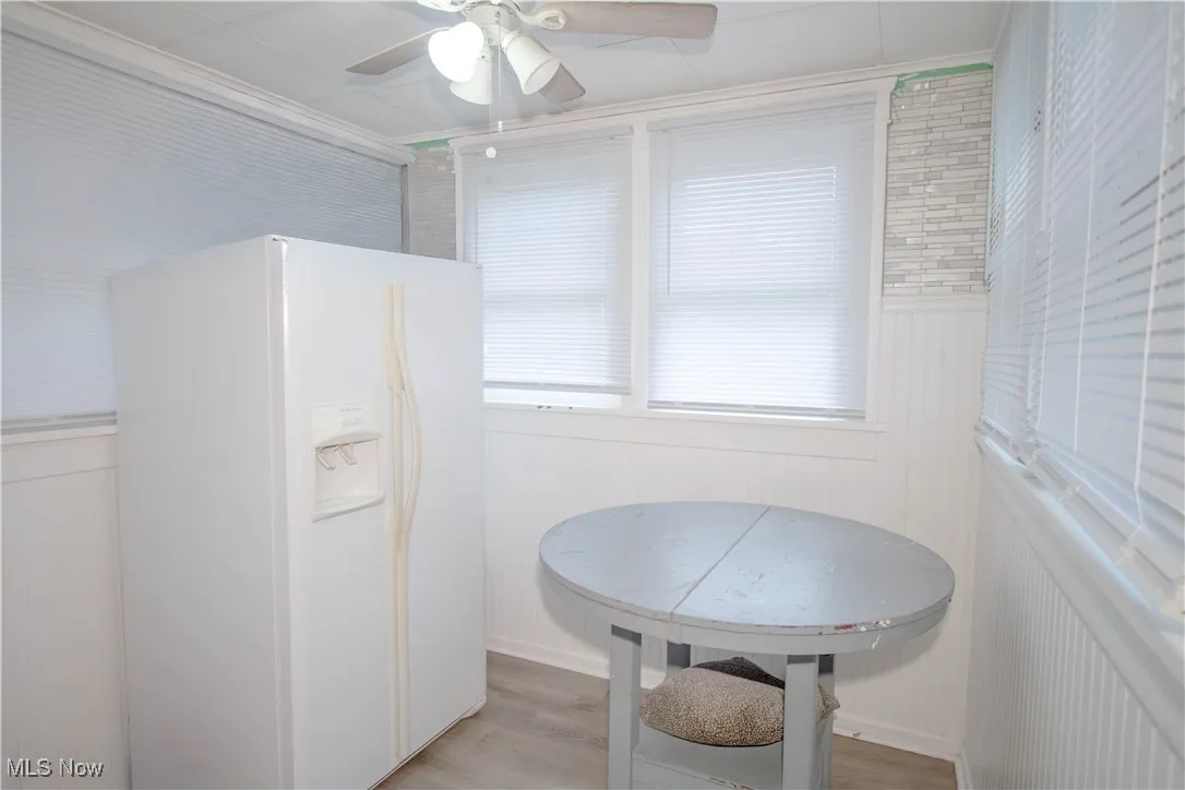 Dining area with light wood-style floors, a ceiling fan, and ornamental molding