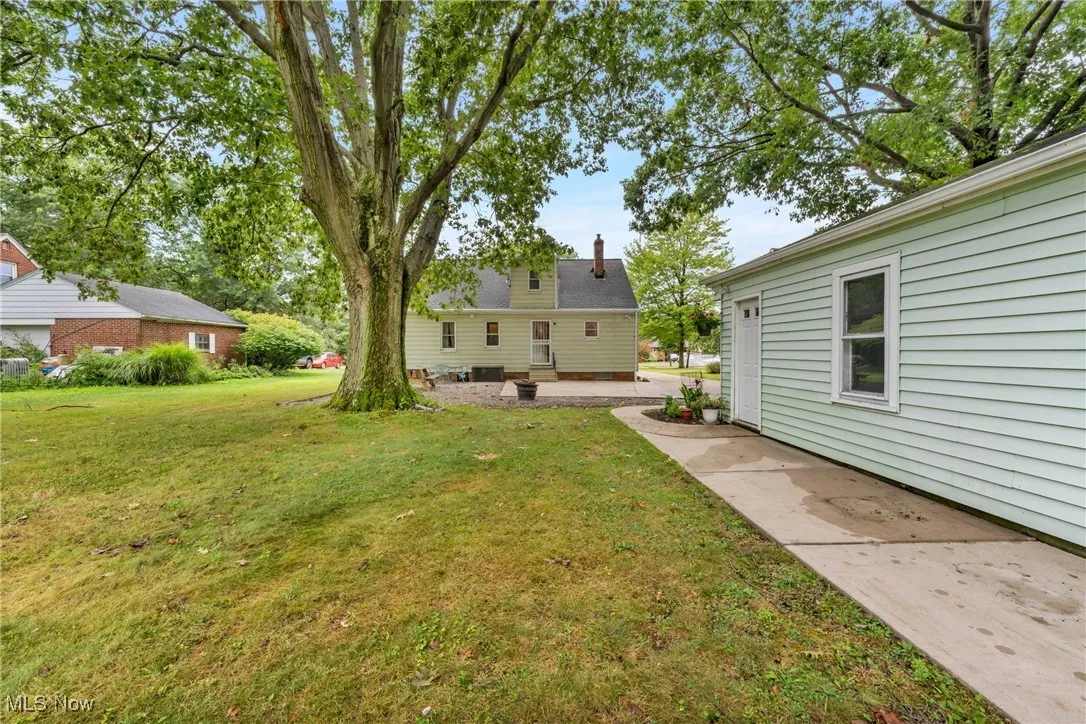 View of grassy yard featuring a patio area