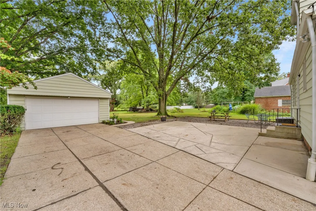 View of patio with an outbuilding and a detached garage
