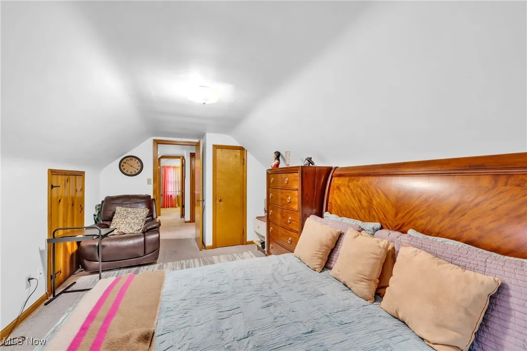 Bedroom featuring vaulted ceiling and light colored carpet