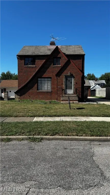Tudor home with brick siding and a chimney