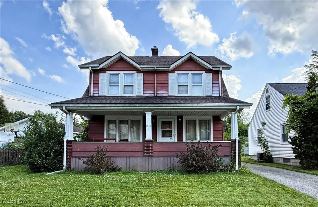 View of front facade featuring covered porch, a front lawn, a chimney, and a shingled roof