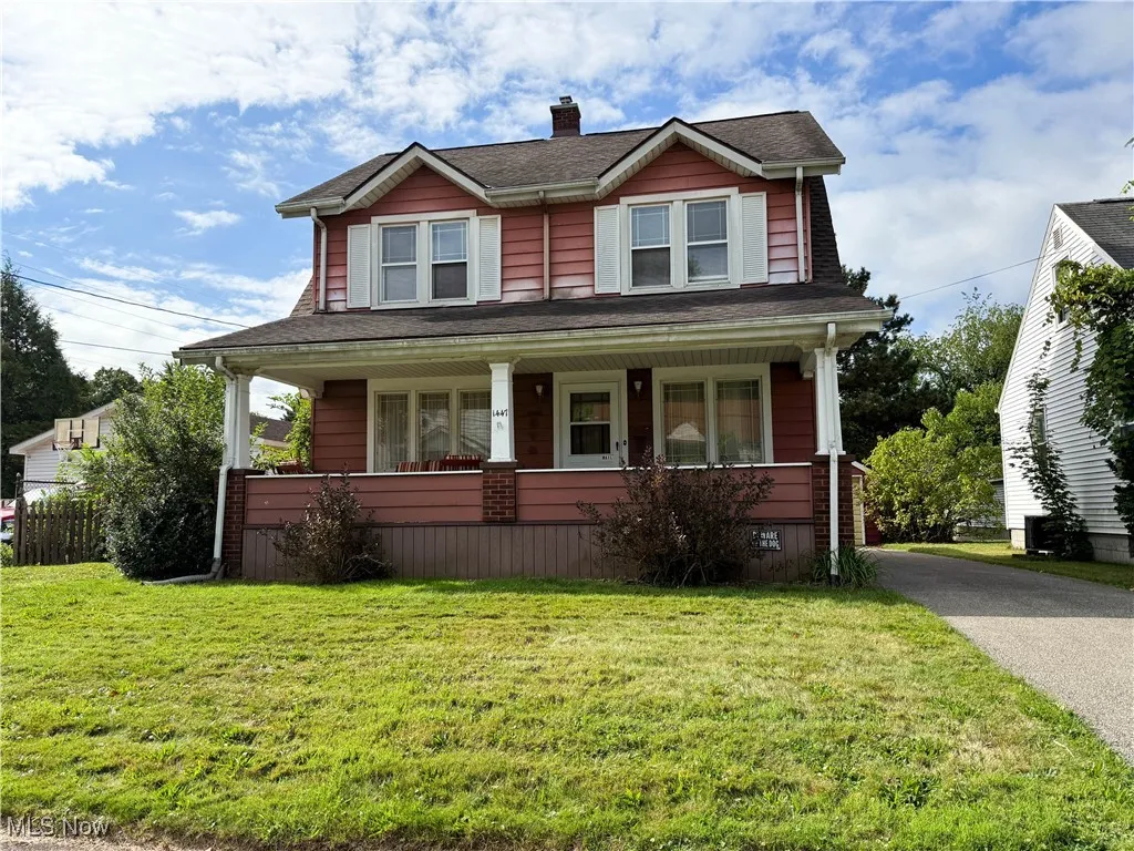 View of front facade featuring covered porch, a front lawn, a chimney, and a shingled roof