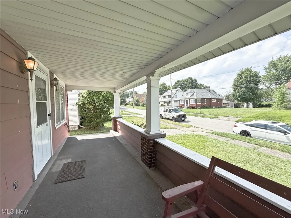 Covered porch featuring a residential view