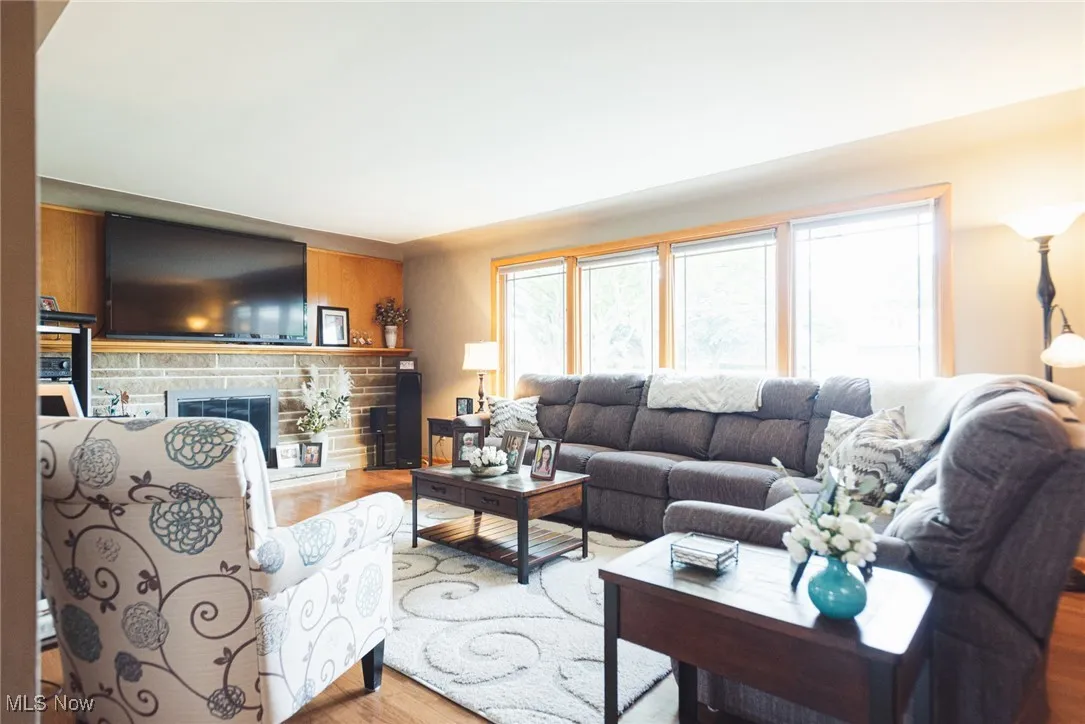 Living room with wood finished floors and a stone fireplace