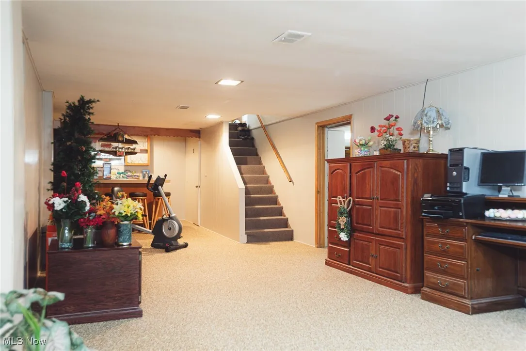 Home office featuring a bar and carpet