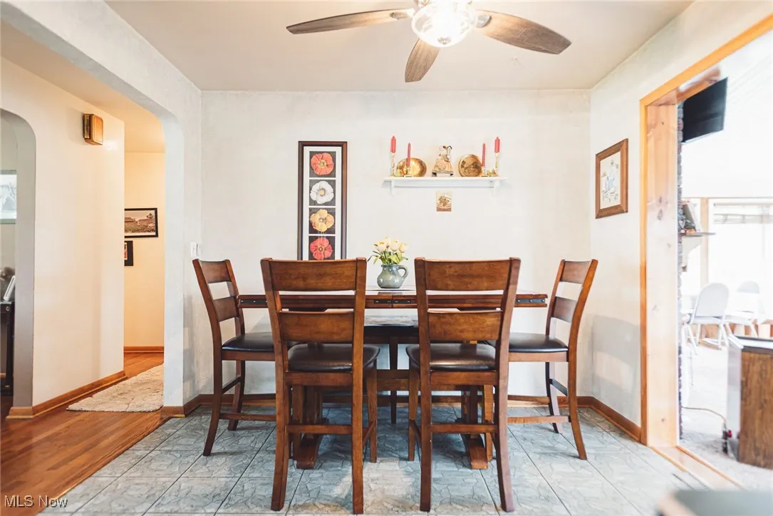 Dining area with arched walkways, ceiling fan, and plenty of natural light