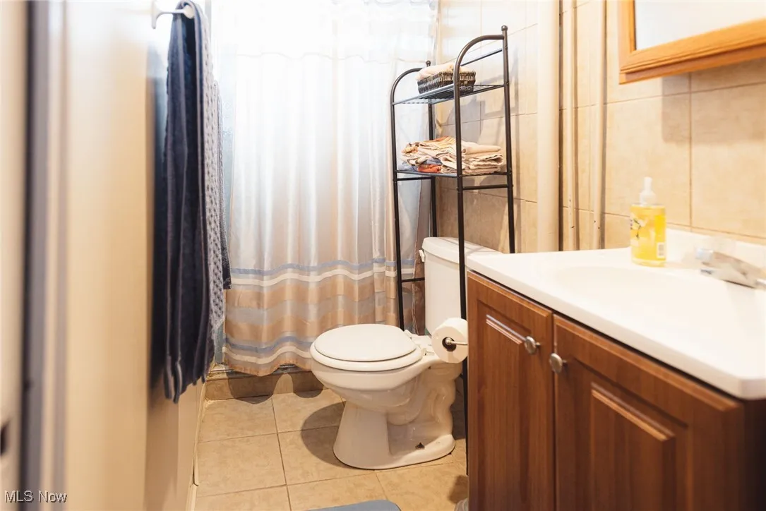 Full bathroom with vanity and light tile patterned floors