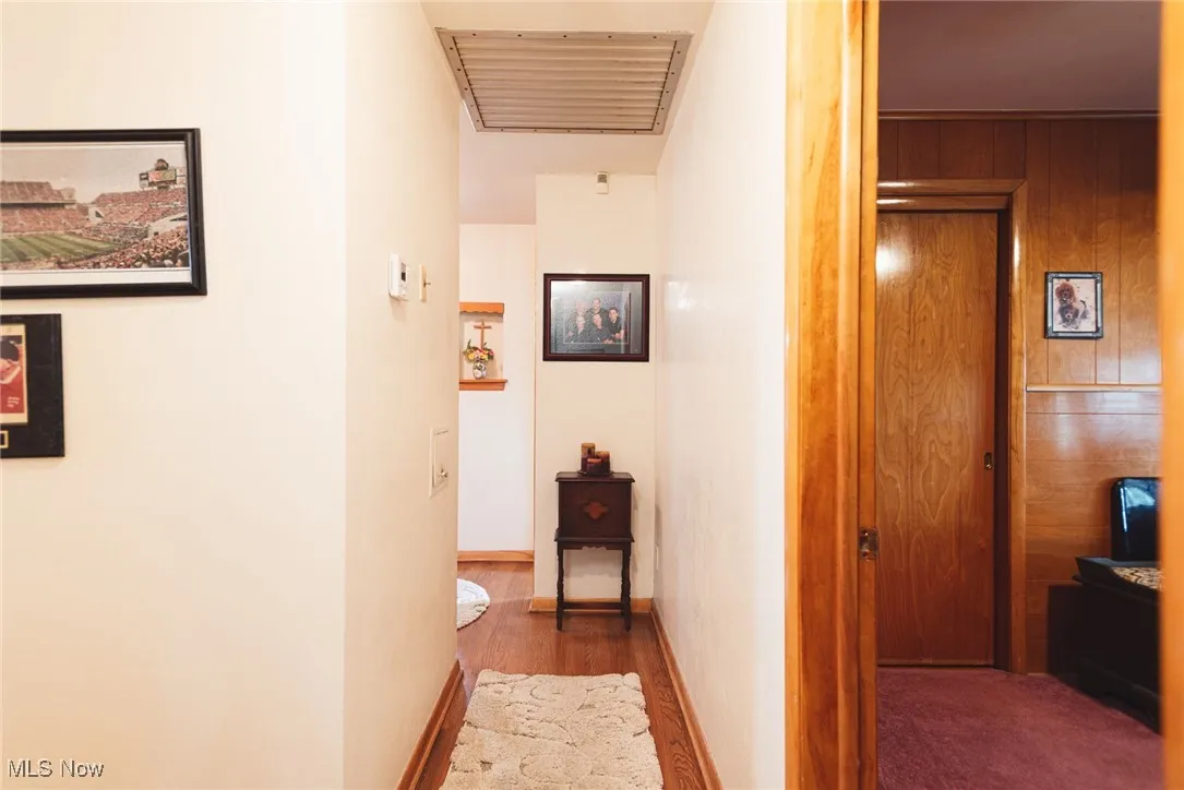Hall featuring wood walls and wood finished floors