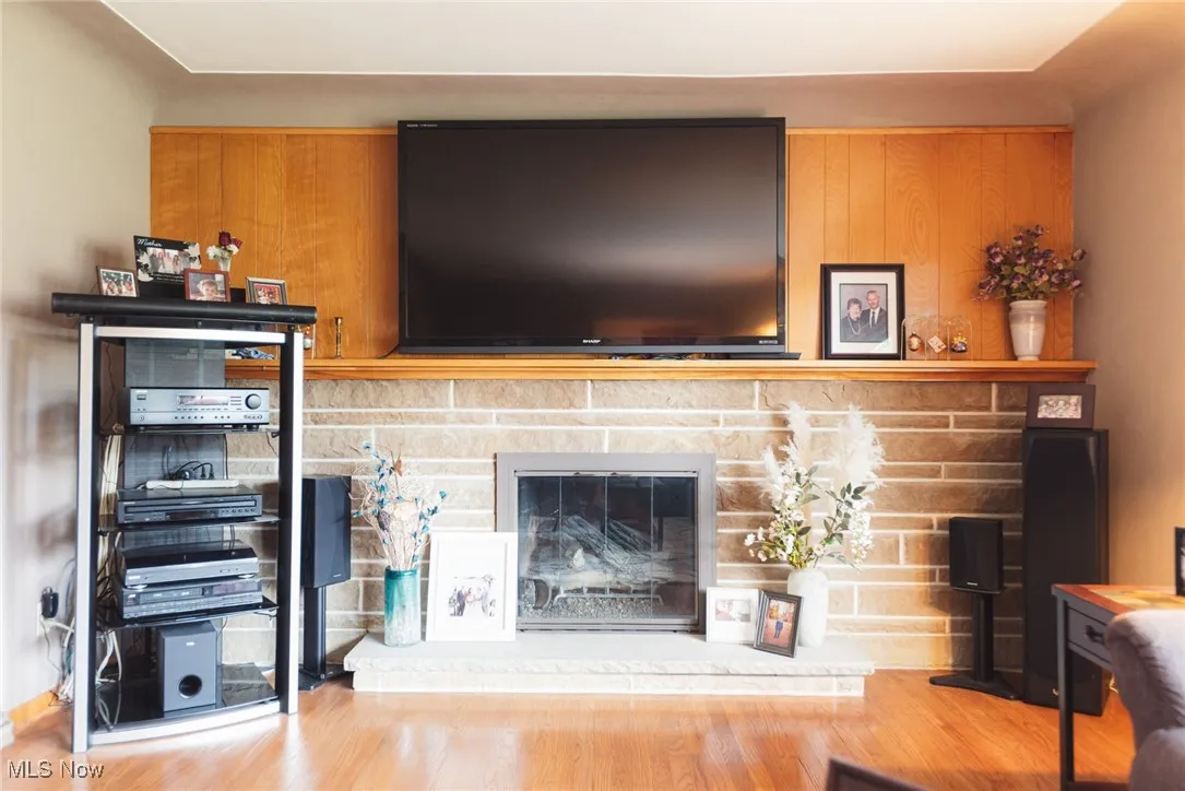 Living room with wood finished floors and a stone fireplace
