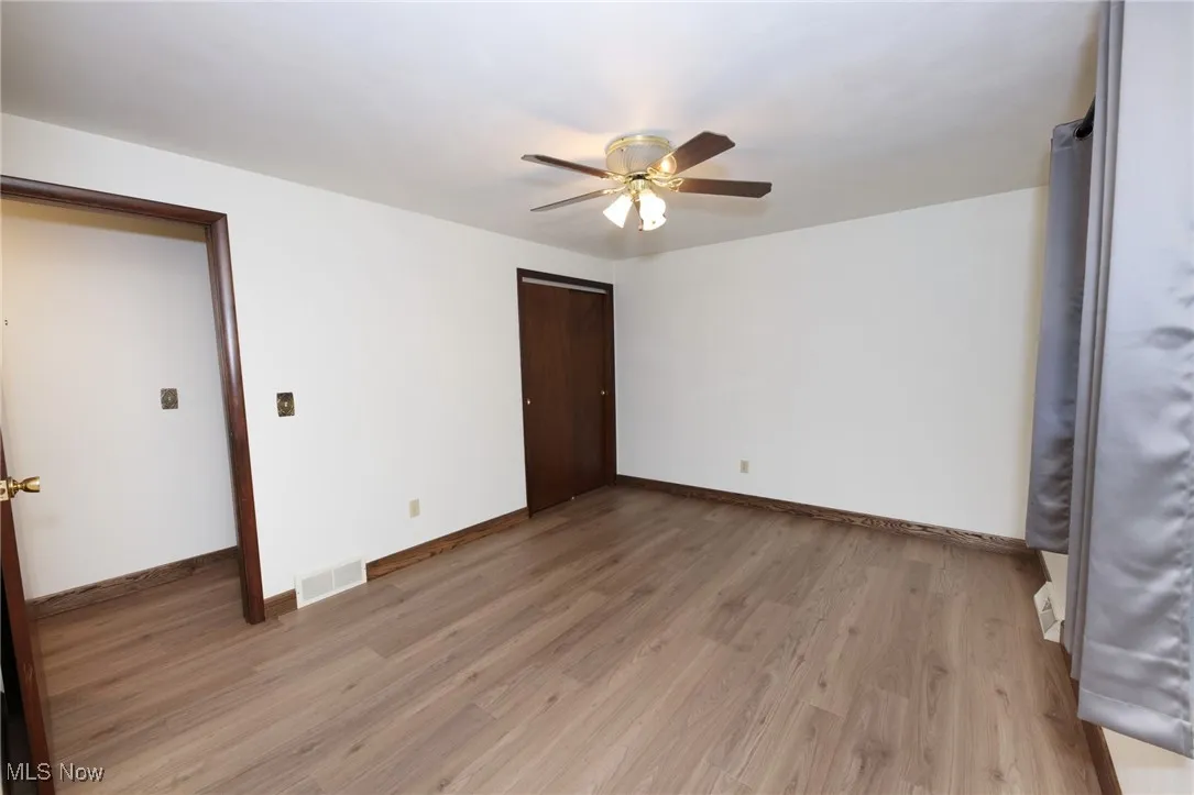 Empty room featuring light wood-style flooring and a ceiling fan