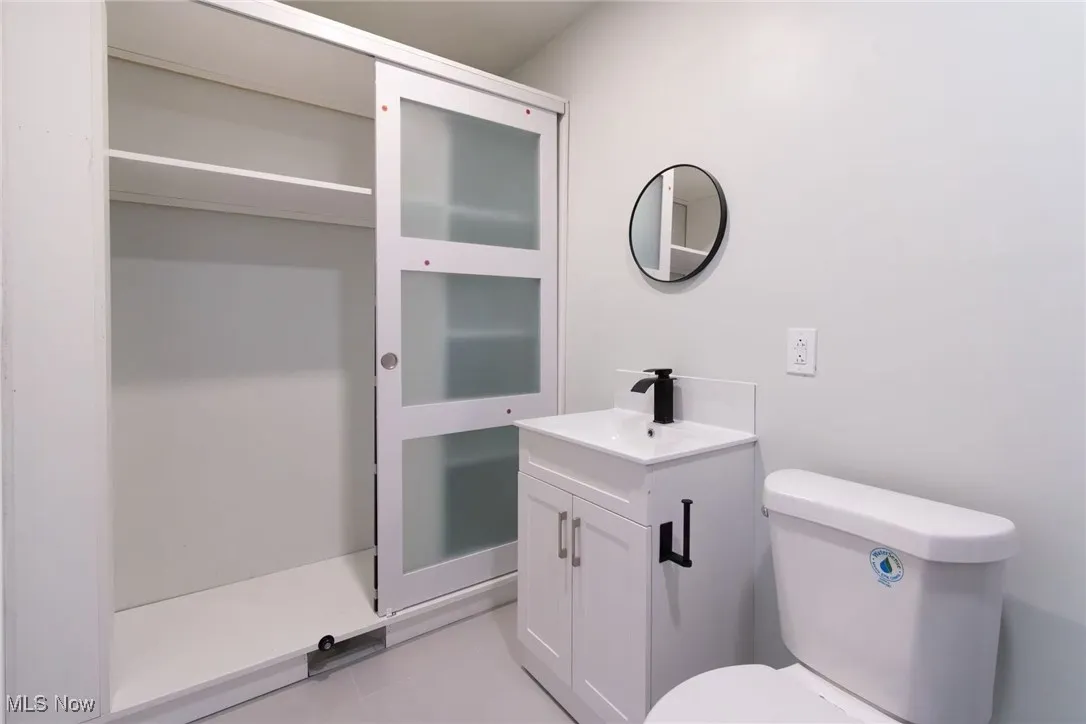 Half bathroom featuring vanity and light tile patterned flooring