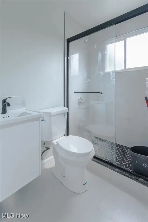 Bathroom with vanity, a shower stall, and light tile patterned flooring