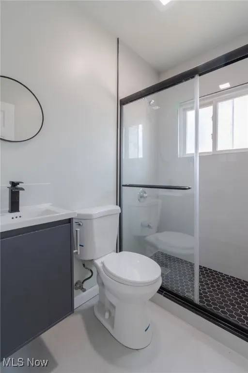 Full bath featuring vanity, a shower stall, and tile patterned flooring