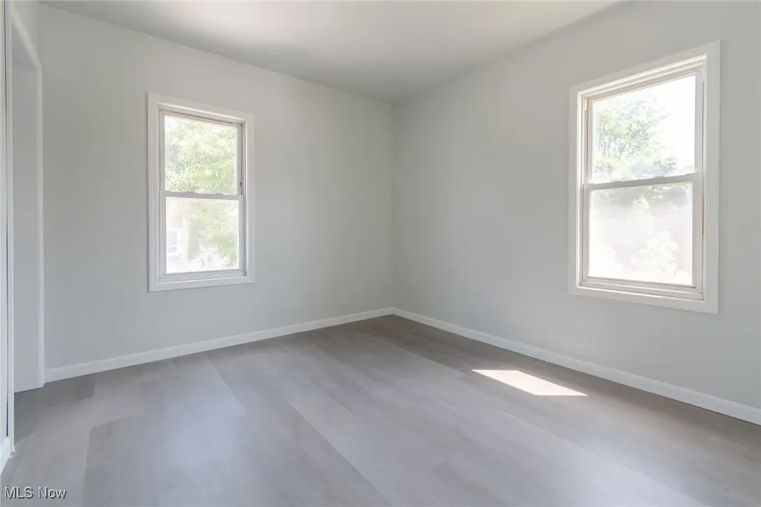 Empty room with baseboards and light wood-style floors