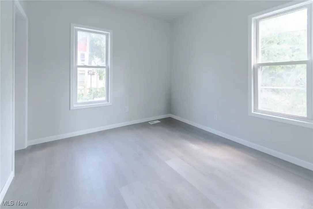 Unfurnished room with baseboards and light wood-style flooring