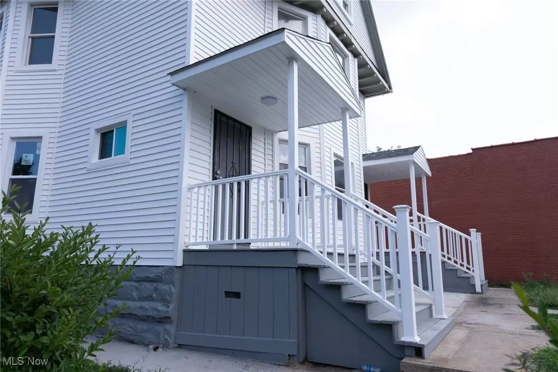 View of home's exterior featuring stairway and covered porch