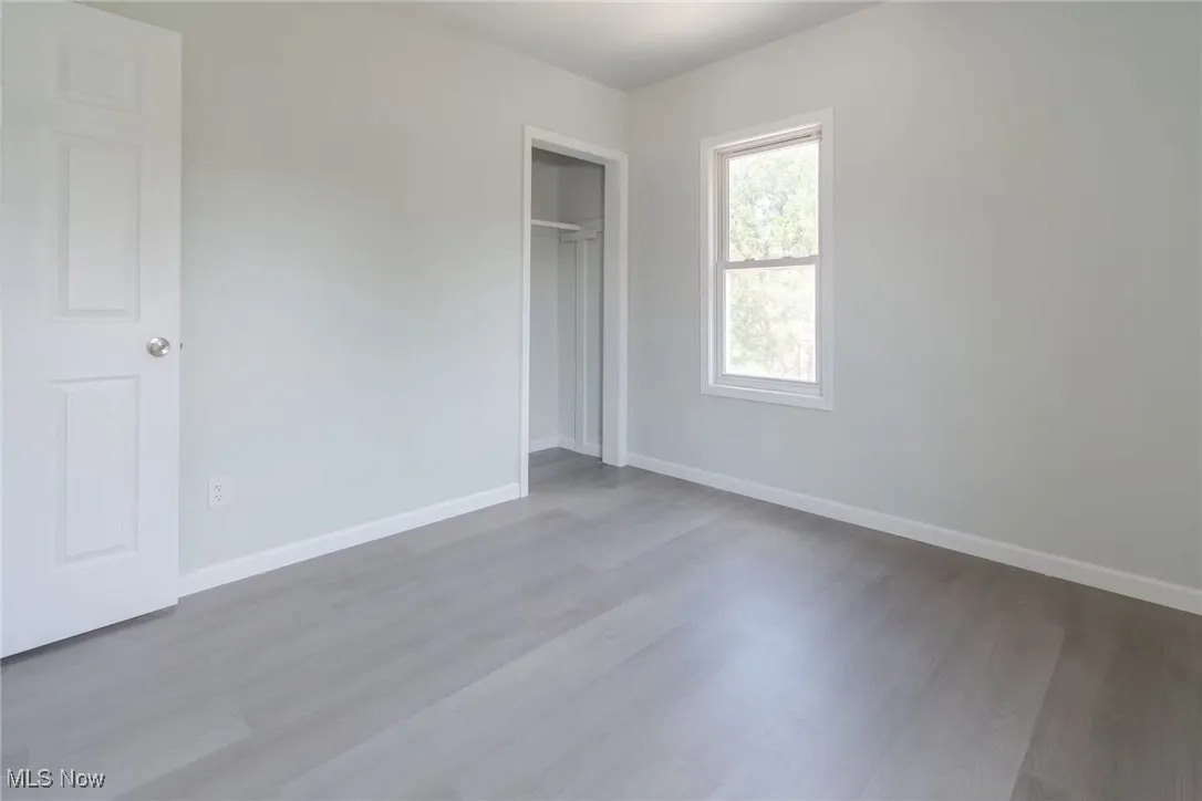 Unfurnished bedroom with wood finished floors and a closet