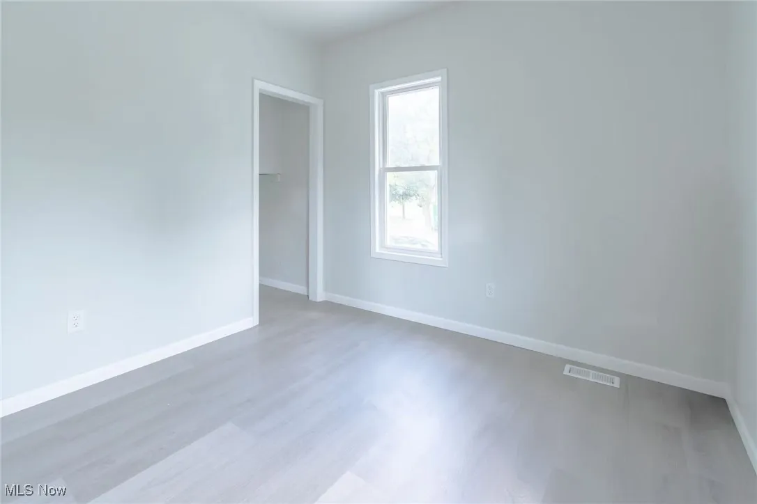 Unfurnished room with baseboards and wood finished floors