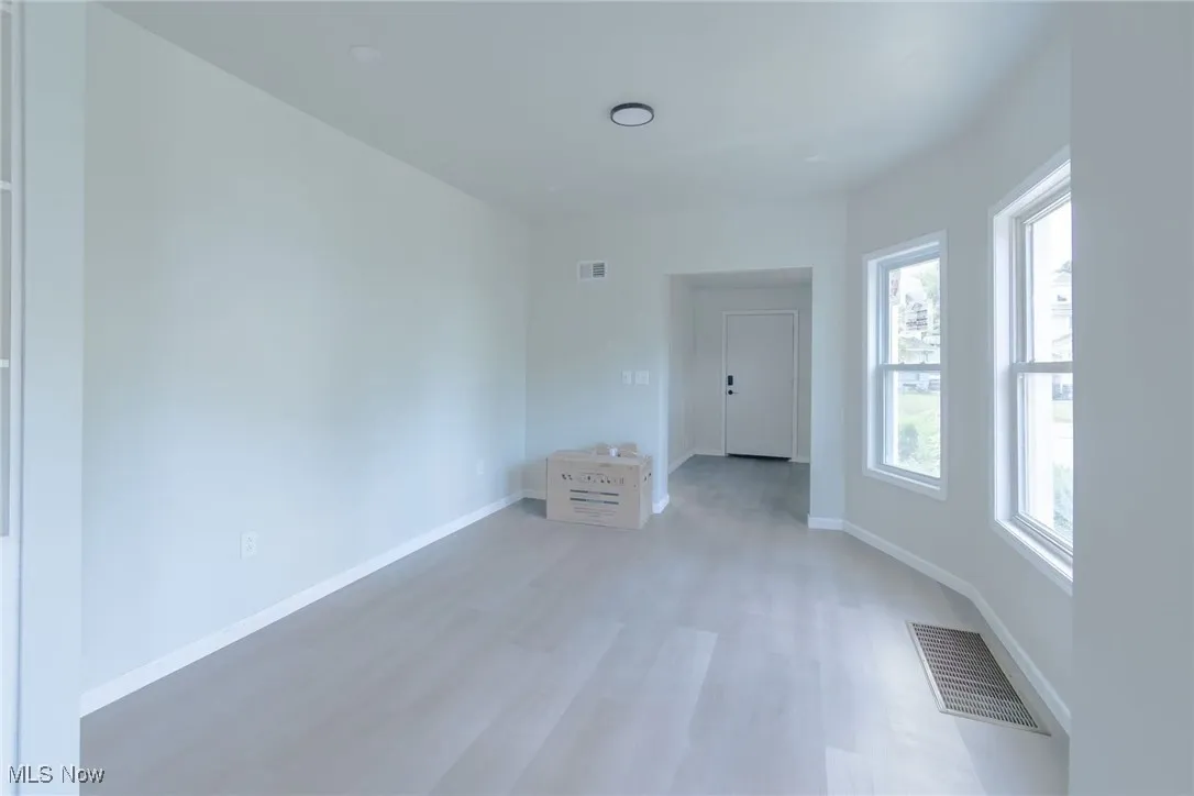 Spare room featuring light wood-type flooring and baseboards