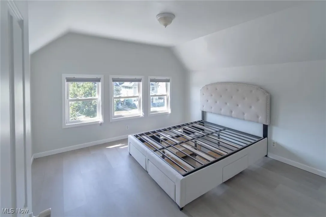 Bedroom with vaulted ceiling and wood finished floors