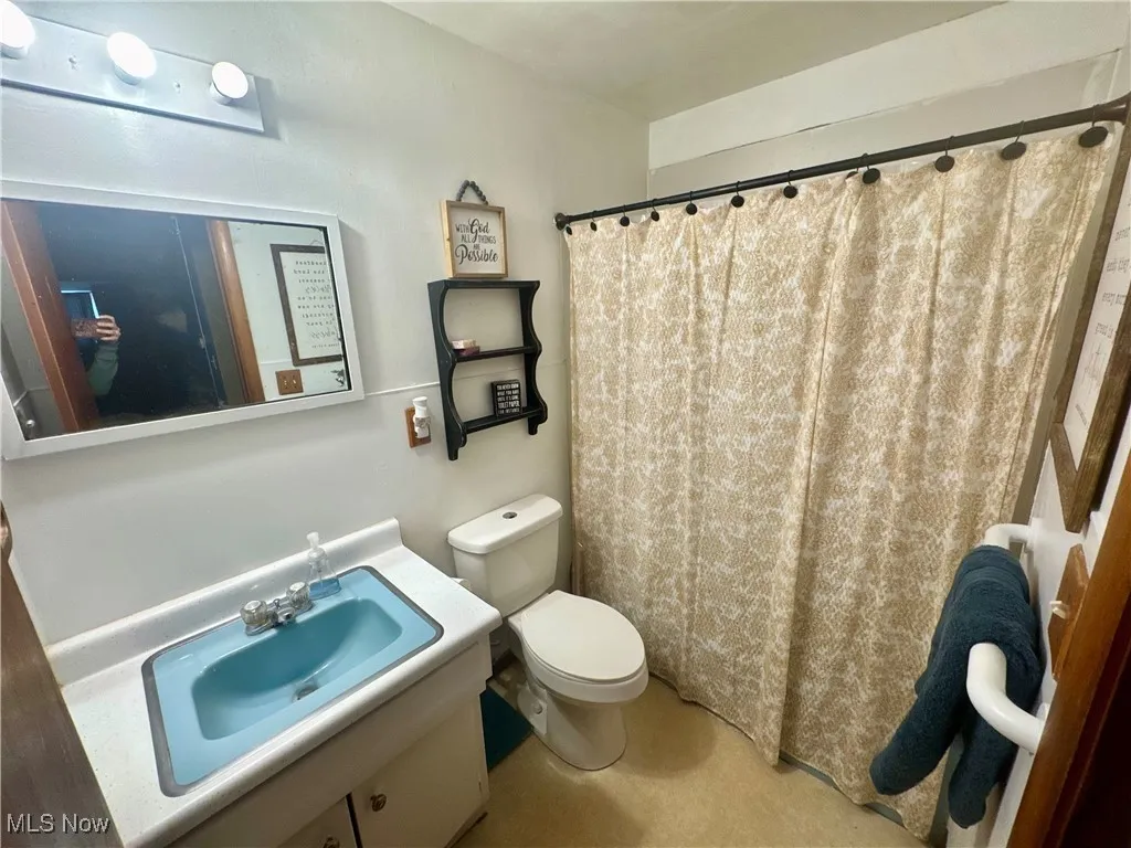 Bathroom featuring a shower with shower curtain and vanity
