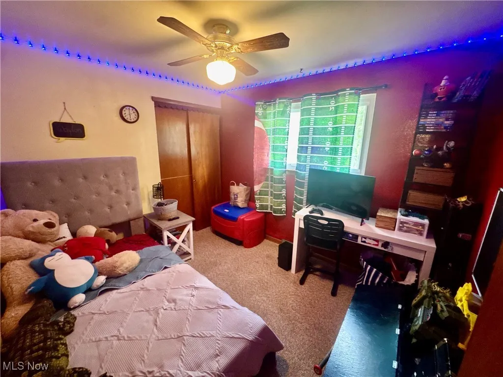 Bedroom with light colored carpet and ceiling fan