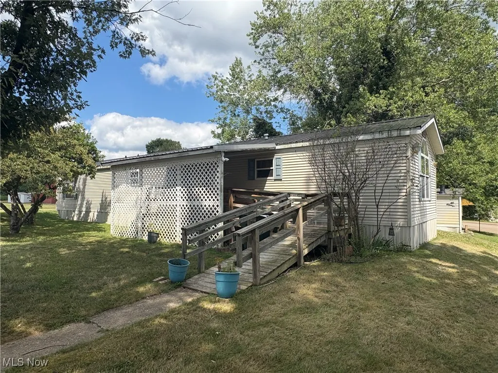 front of house with a lawn and a wooden deck