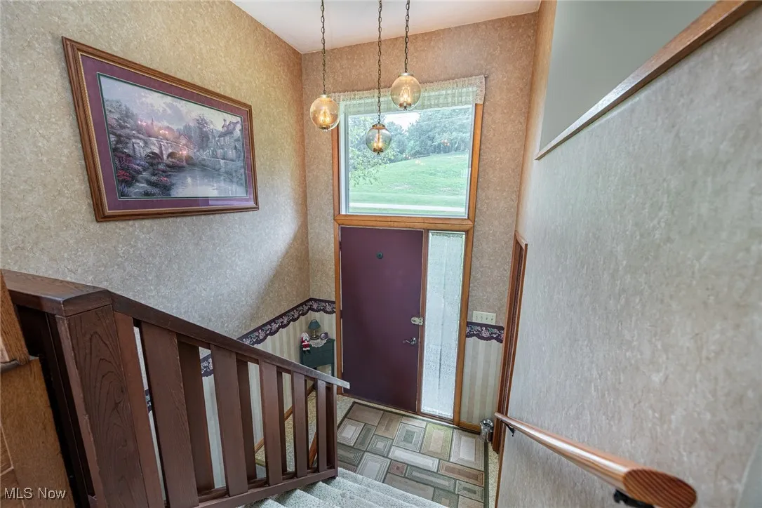 Entrance foyer with wallpapered walls and stairs