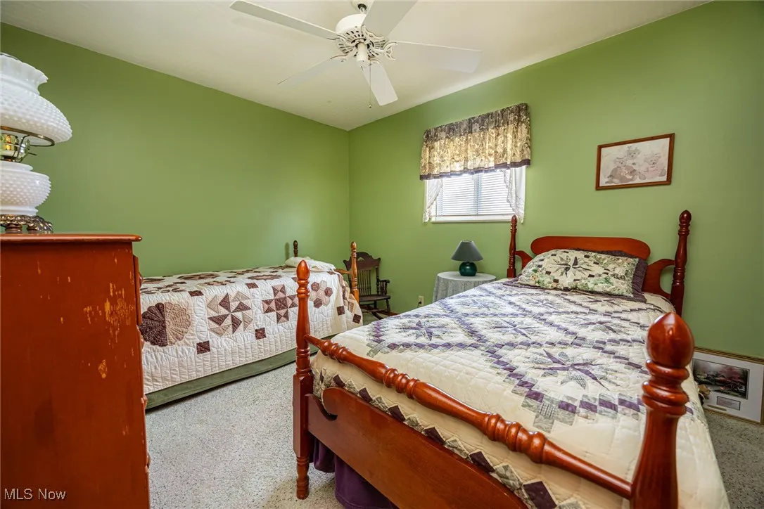 Carpeted bedroom with a ceiling fan
