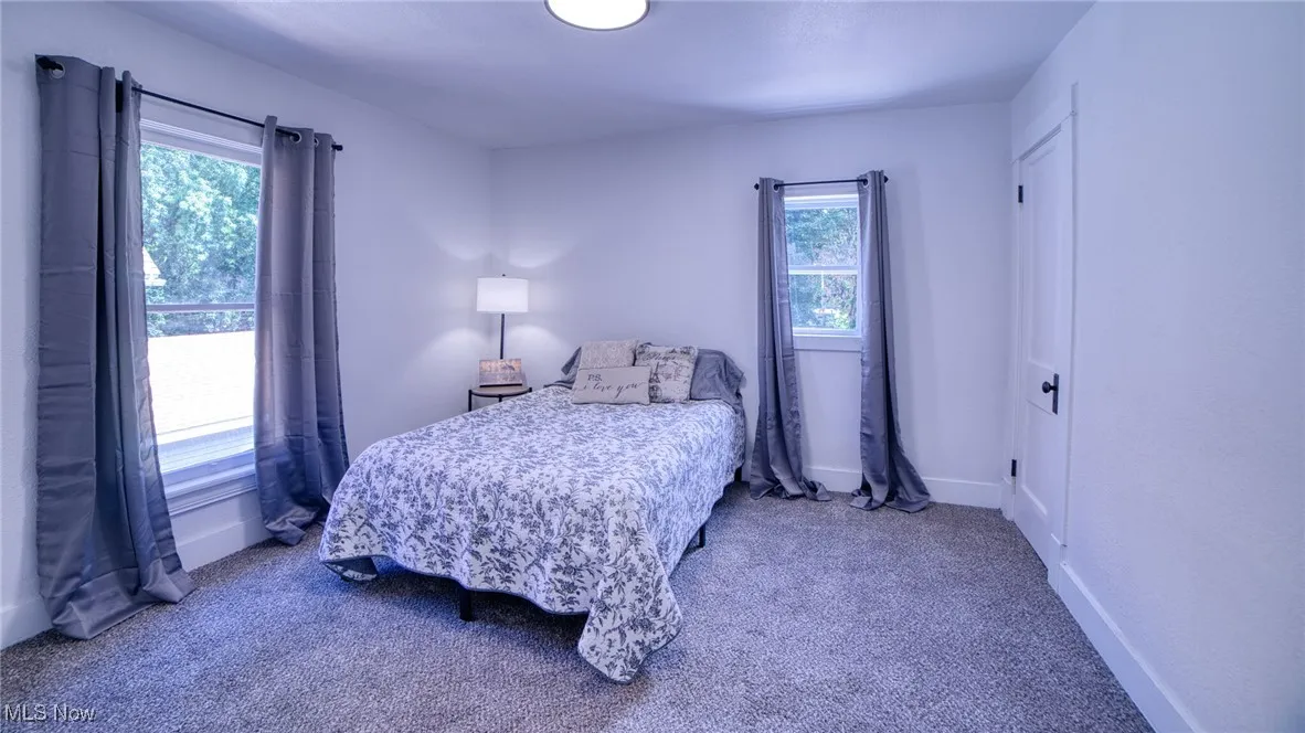 Bedroom featuring carpet and baseboards