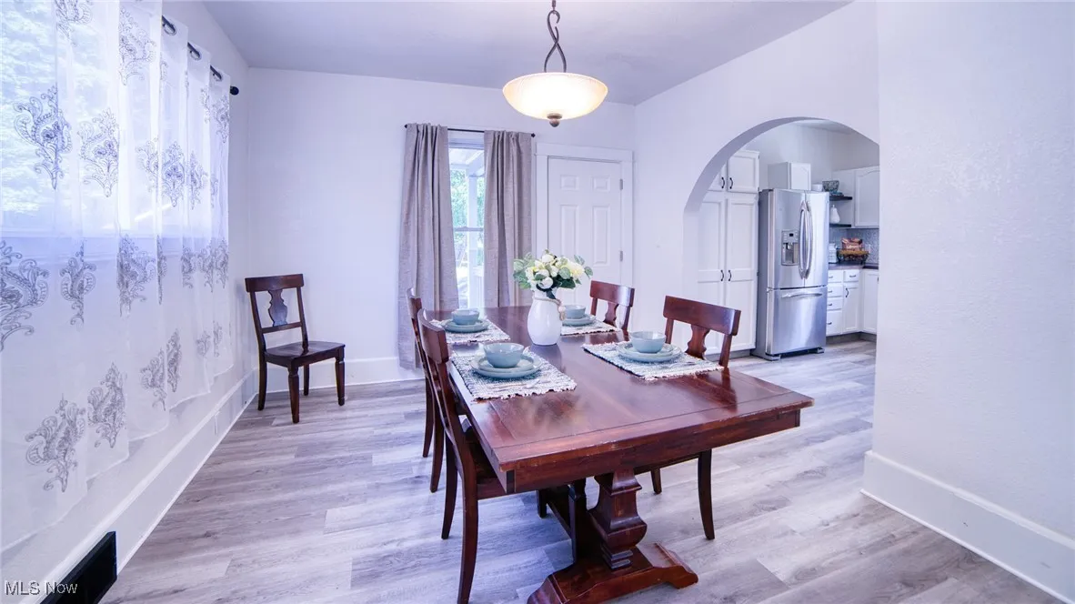 Dining space with arched walkways and LVP flooring