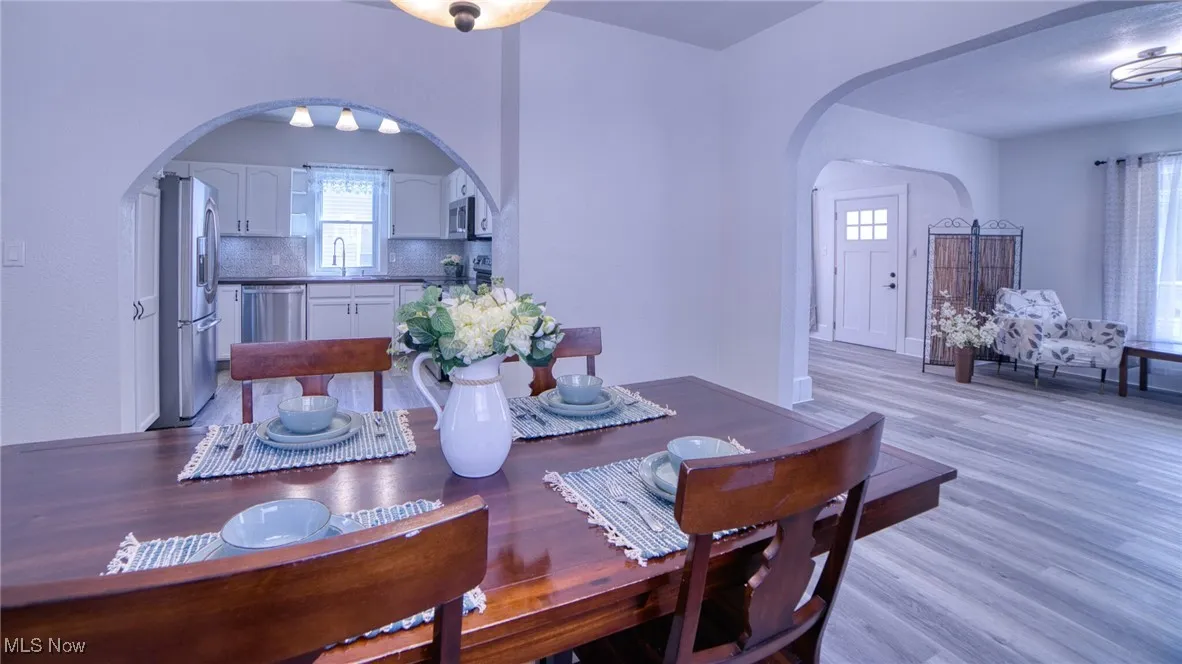 Dining room featuring arched walkways and light LVP floors
