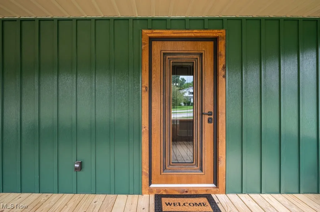 Doorway to property featuring board and batten siding