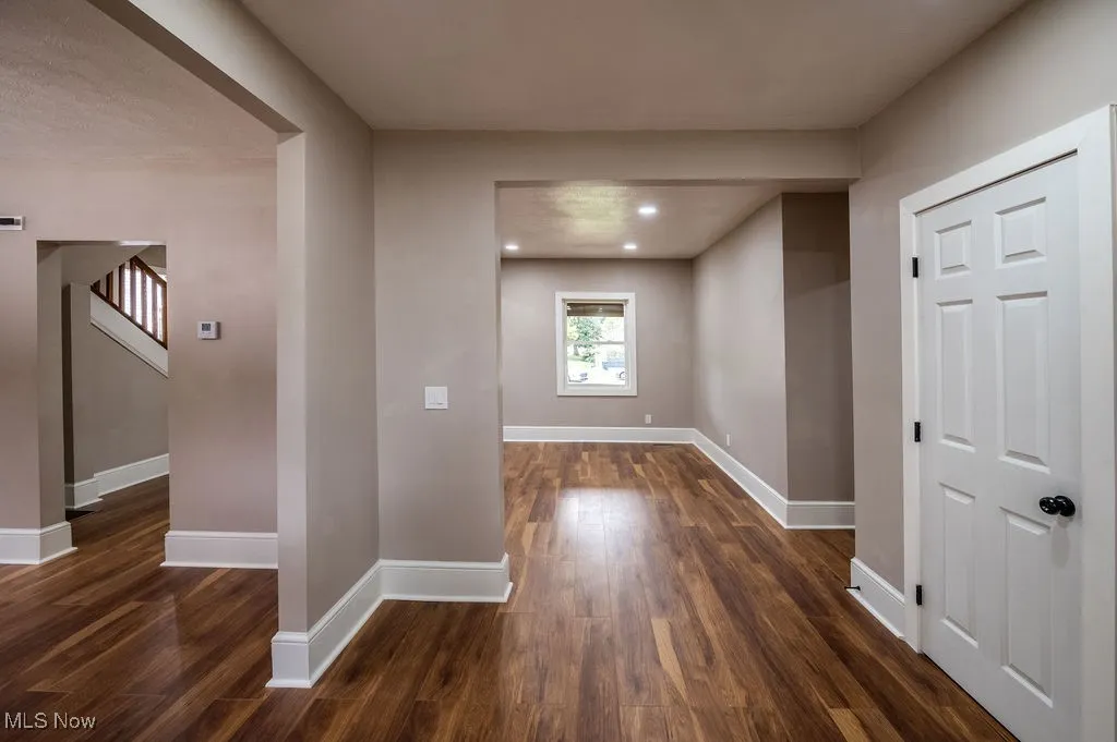 Hall with dark wood finished floors and recessed lighting